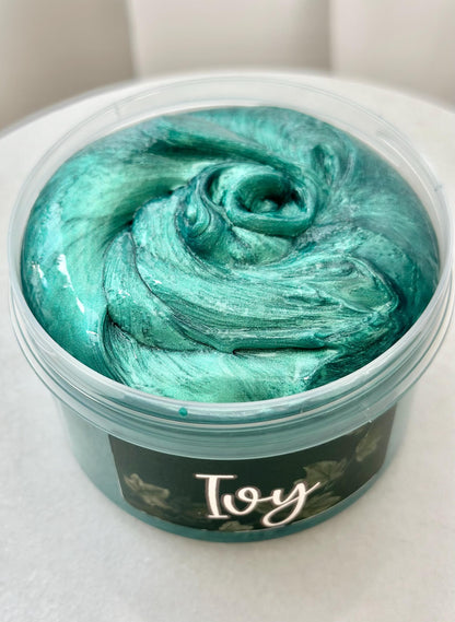 EinDunkelgrünMetallicschimmernderSlime, in einem transparentem Container. Das Etikett ist Dunkelgrün, mit Efeuranken. Es stehtdas Wort Ivy darauf.